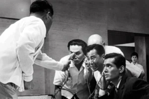 Hombres angustiados escuchando una llamada telefónica en una escena del thriller japonés El Infierno del Odio (1963) de Akira Kurosawa
