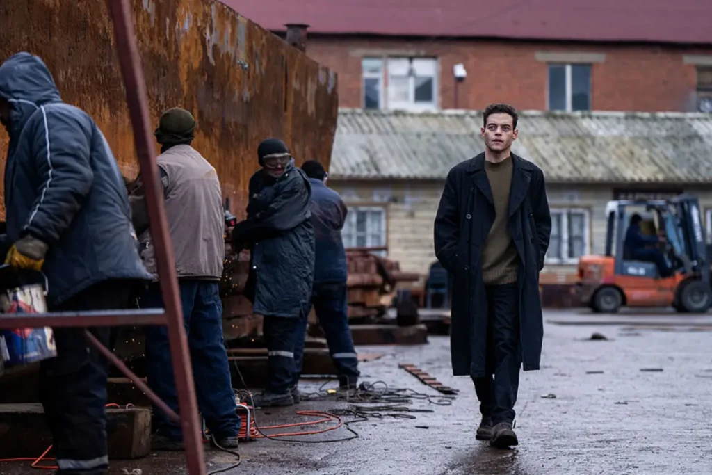 Rami Malek en una escena de tensión en Amateur (2025), thriller de espionaje ambientado en escenarios urbanos oscuros.